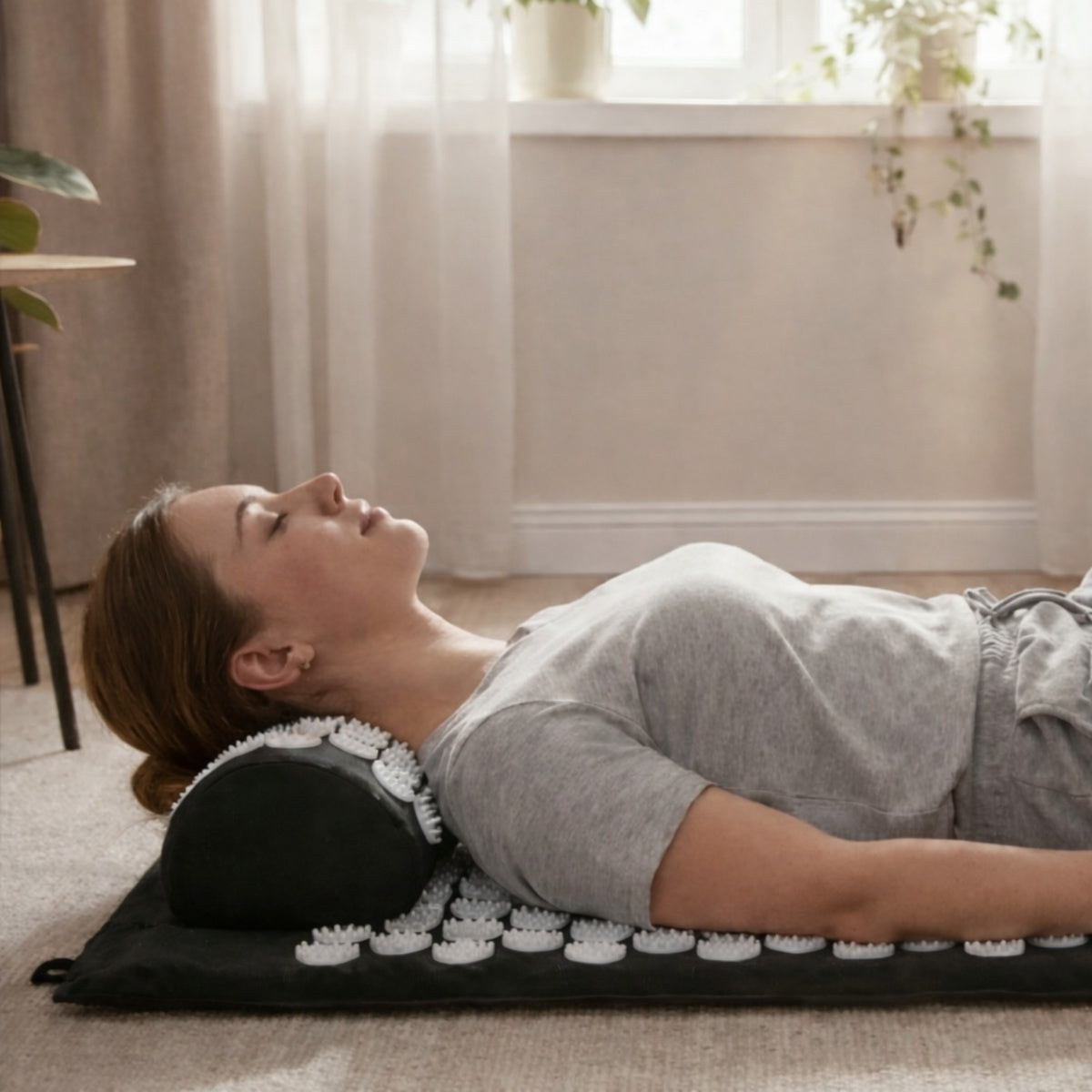 Woman using an acupressure mat and pillow for back and neck muscle relief, demonstrating home therapy for tension and recovery.